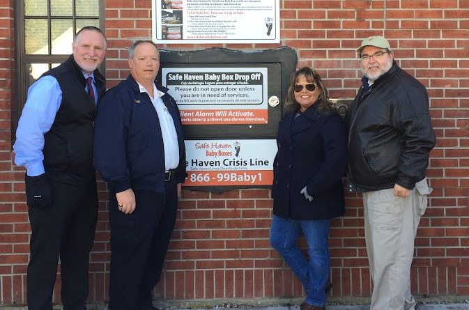 Crown Point Mayor David Uran (left), Crown Point Fire Chief Dave Crane, CEO/founder of Safe Haven Baby Boxes Monica Kelsey, and Grand Knight Dave Stephenson stand in front of the new Safe Haven Baby Box. 